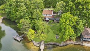 Una propiedad junto al lago con muelle, casa y césped bien cuidado.