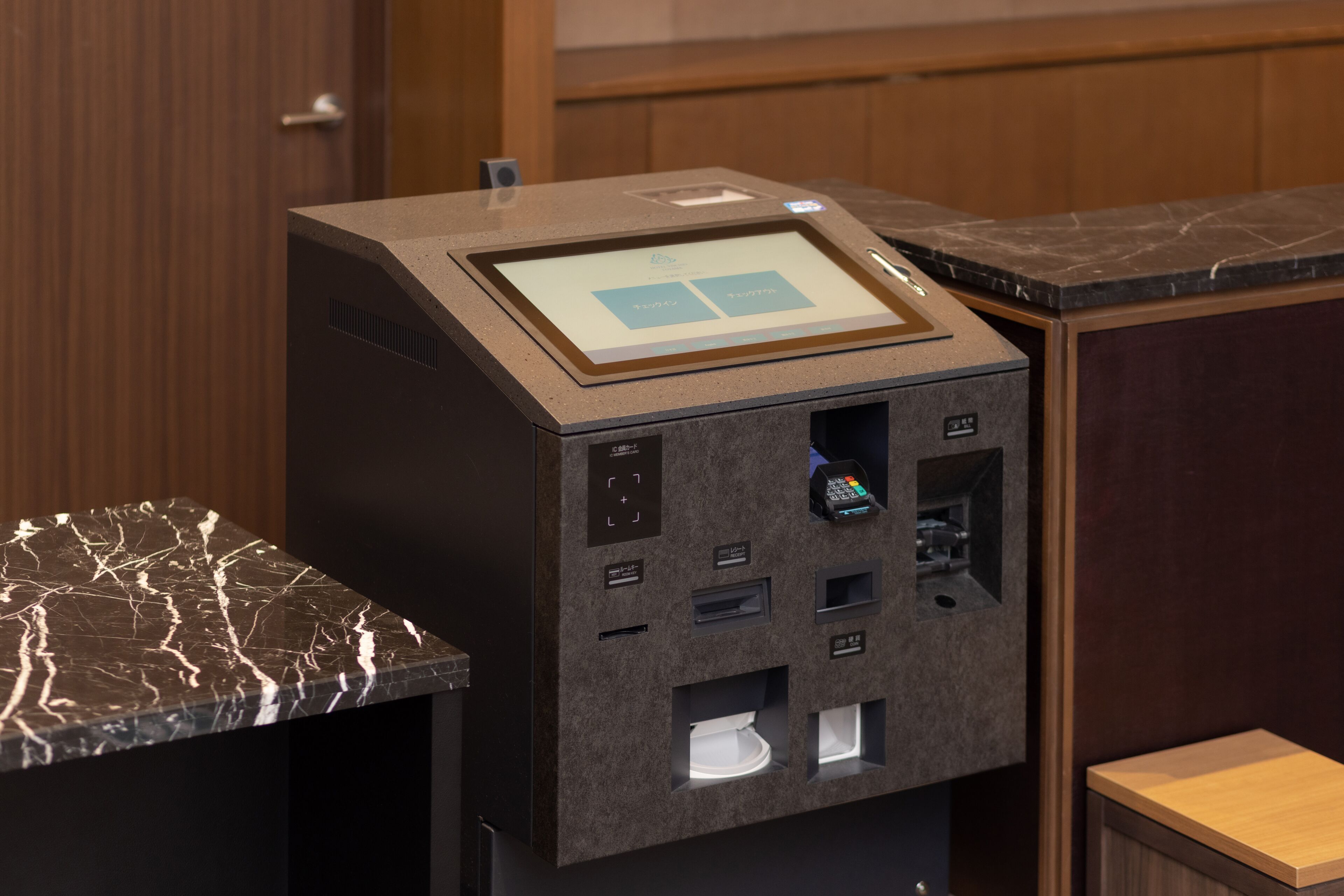 A self-service kiosk with a touchscreen interface, a card reader, and a cash deposit slot.