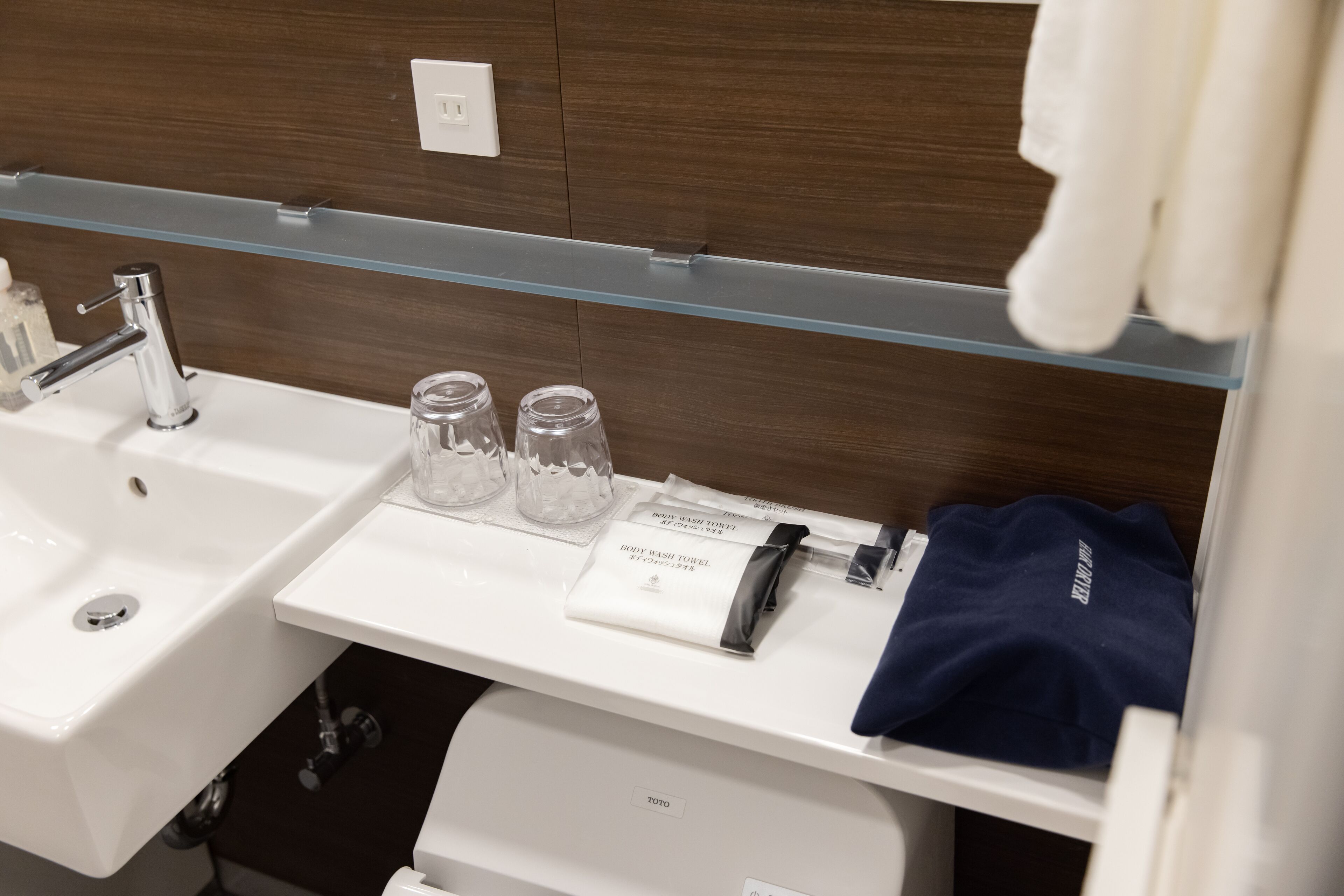 A bathroom with a white sink, a mirror, and a towel rack.