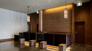 A modern reception area with a dark wood finish, a large digital display, and a clean, tiled floor. - HOTEL VISCHIO TOYAMA by GRANVIA (Toyama)