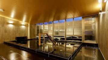 Un espacio interior moderno con techo de madera, pared de vidrio con vistas y suelo reflectante.