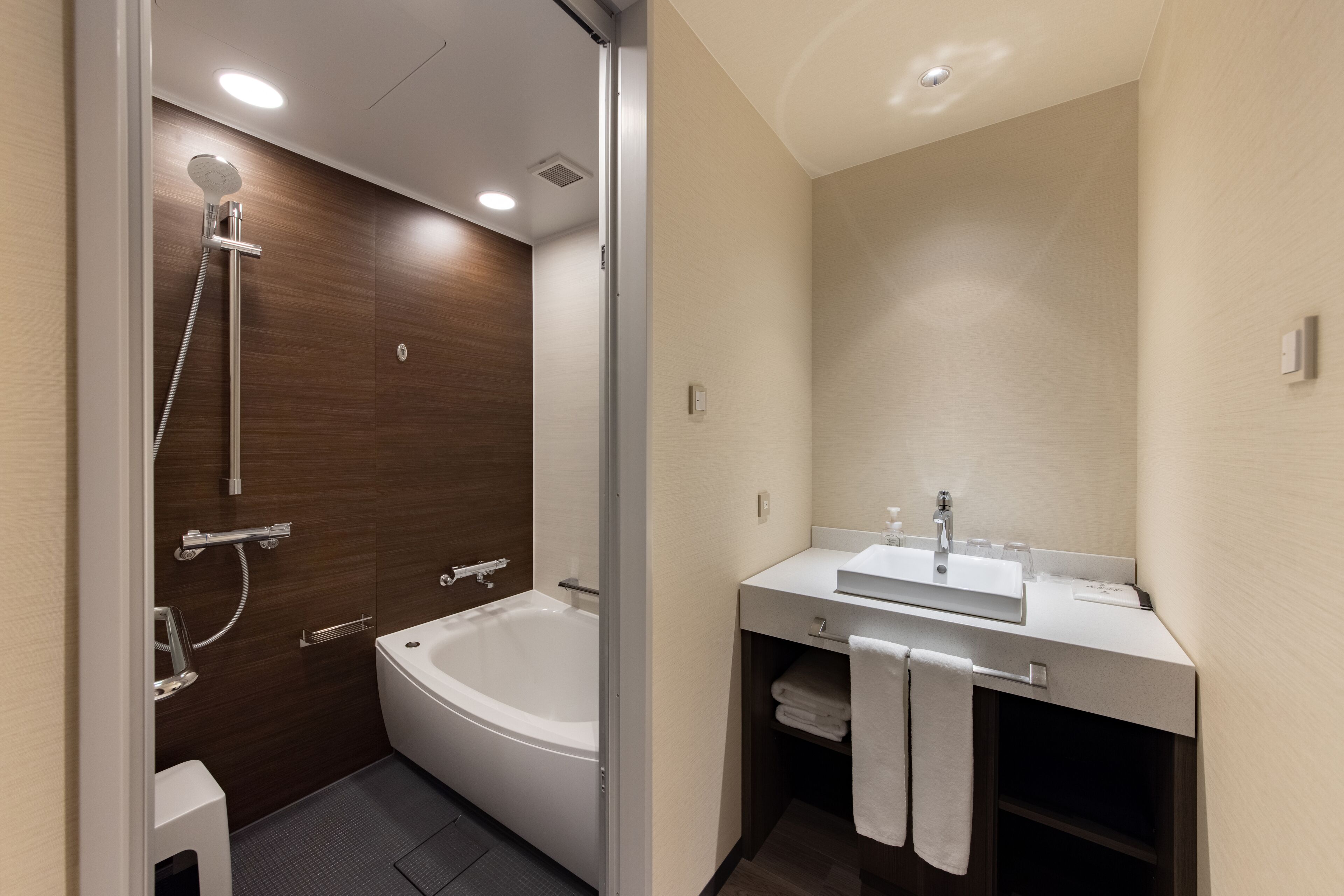 A modern bathroom with a bathtub, shower, and vanity with a sink.