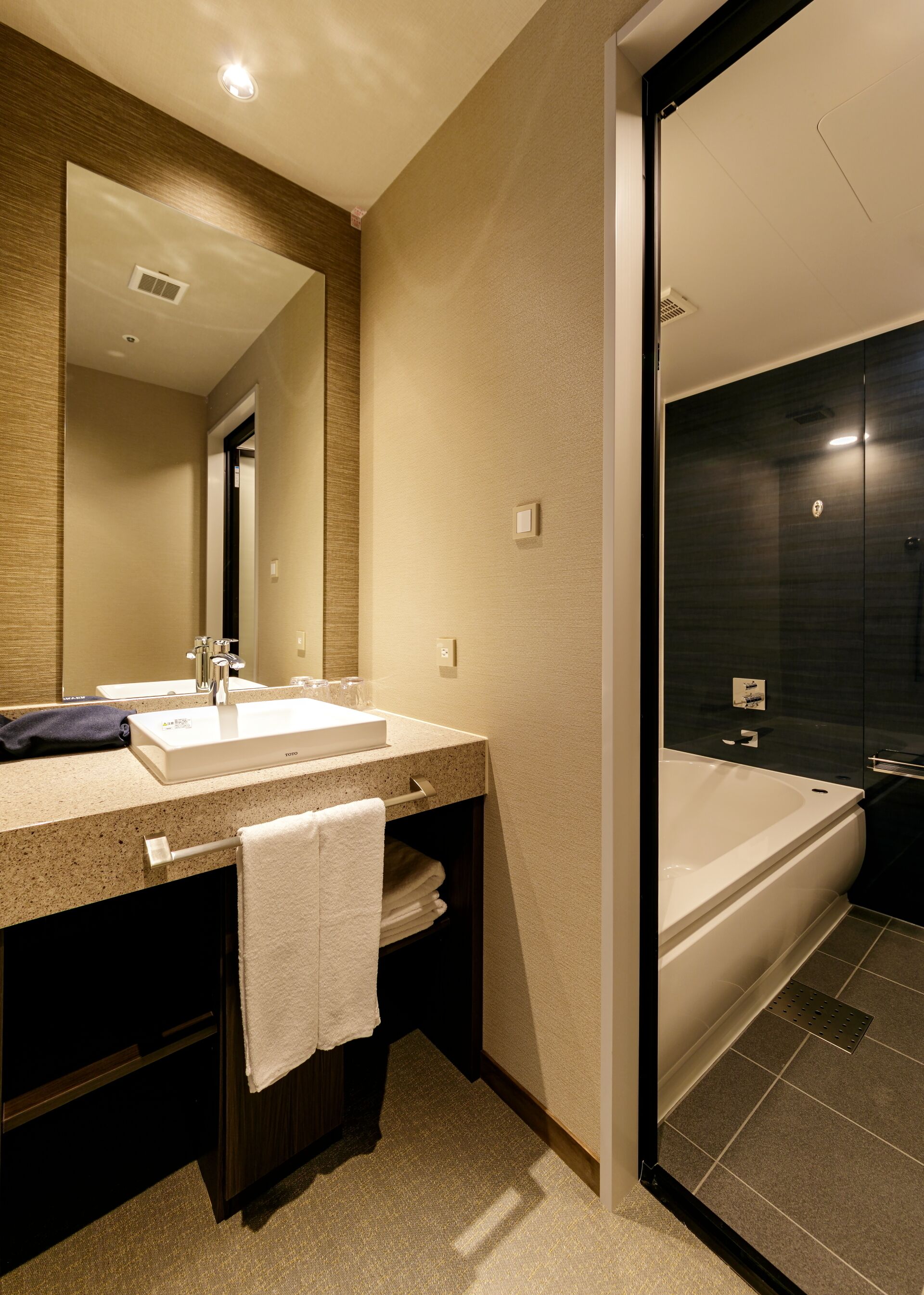 A modern bathroom with a double sink, a large mirror, and a separate shower area.