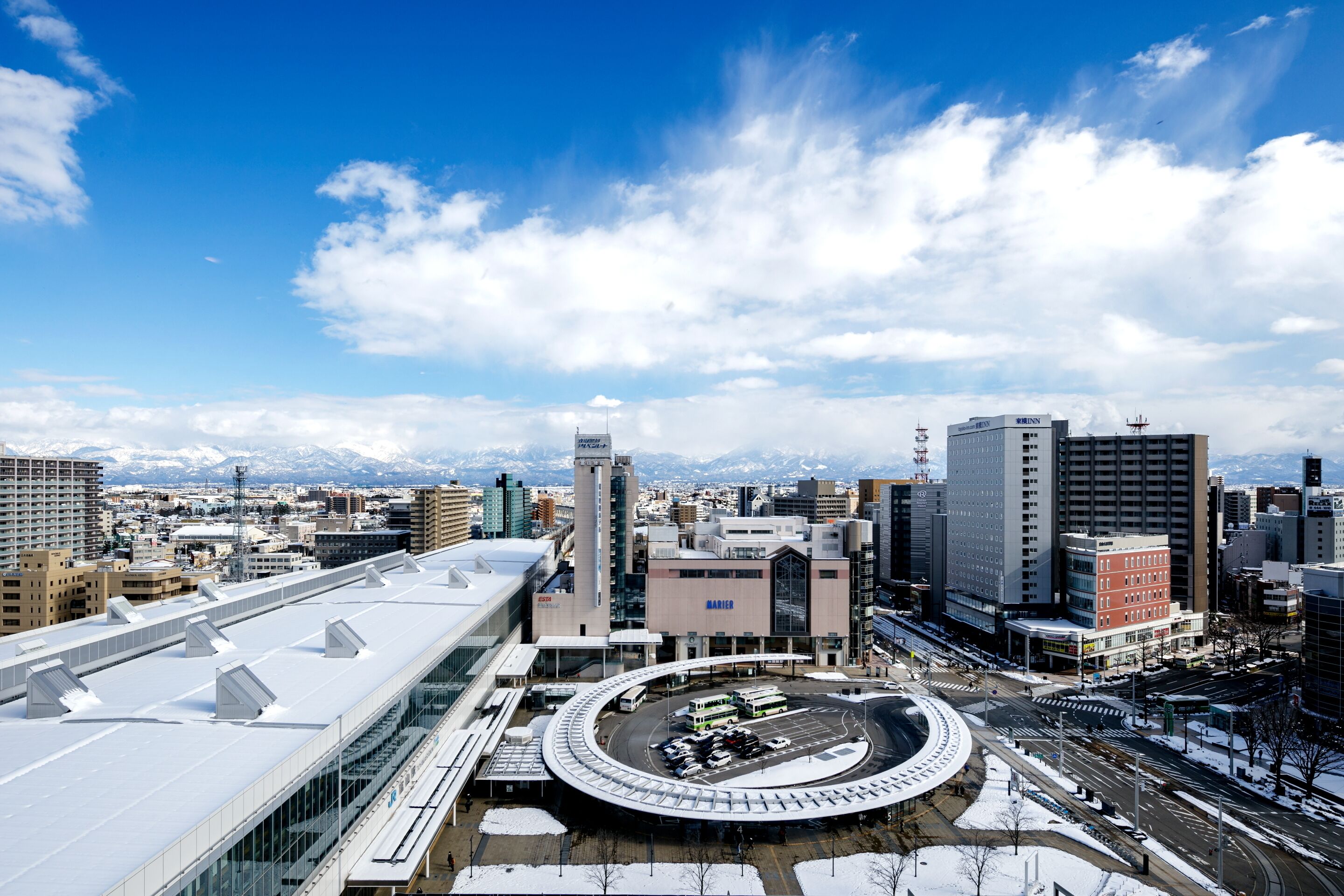 A modern urban area with a large circular plaza surrounded by buildings, including a prominent bank and a hospital.