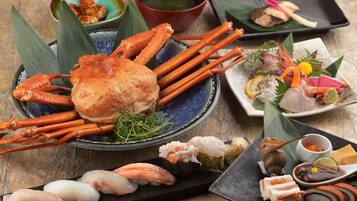 A variety of seafood dishes including crab legs, sashimi, and sushi on a table.