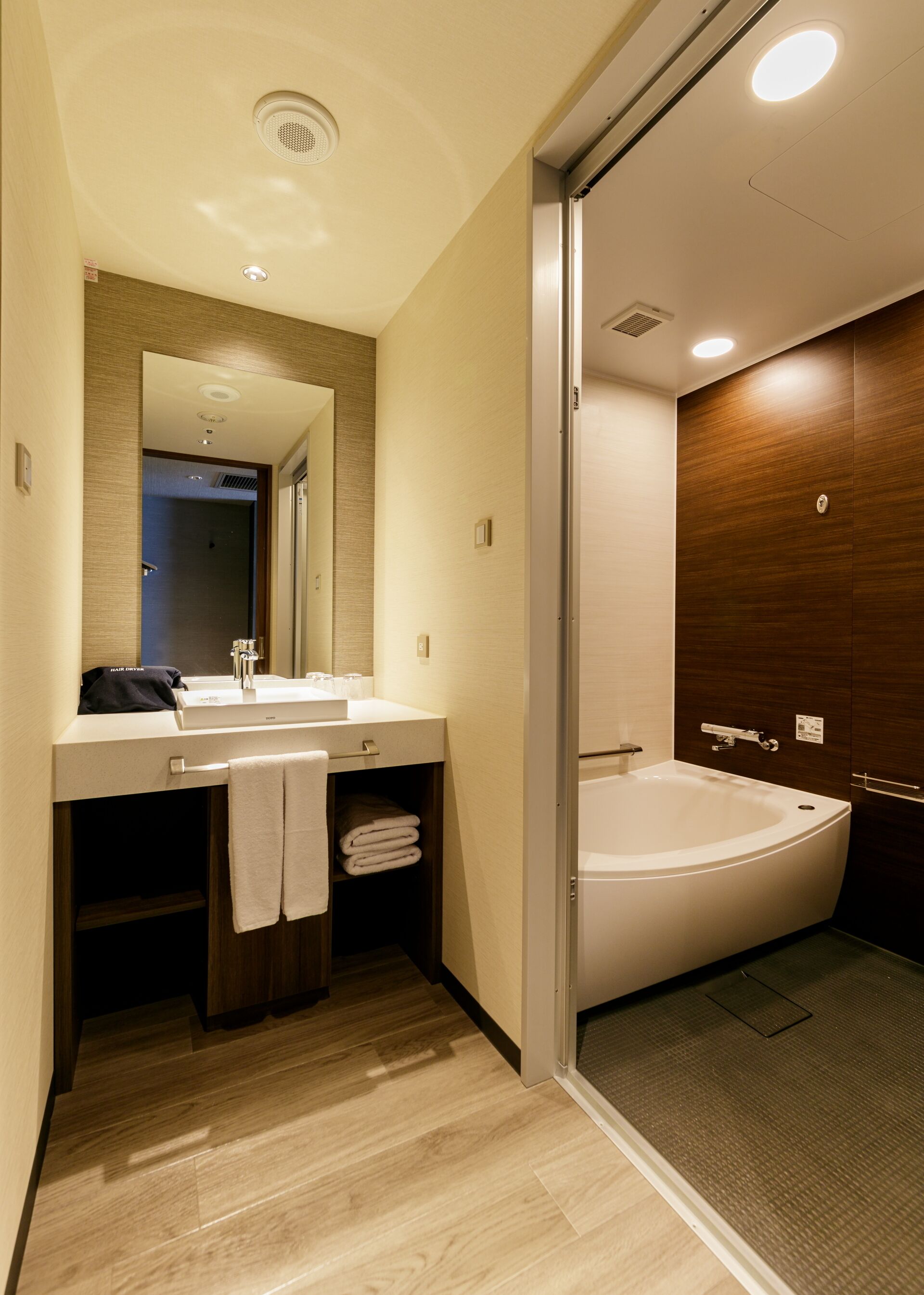 Une salle de bain moderne avec une grande baignoire, un lavabo avec un miroir et un porte-serviettes.