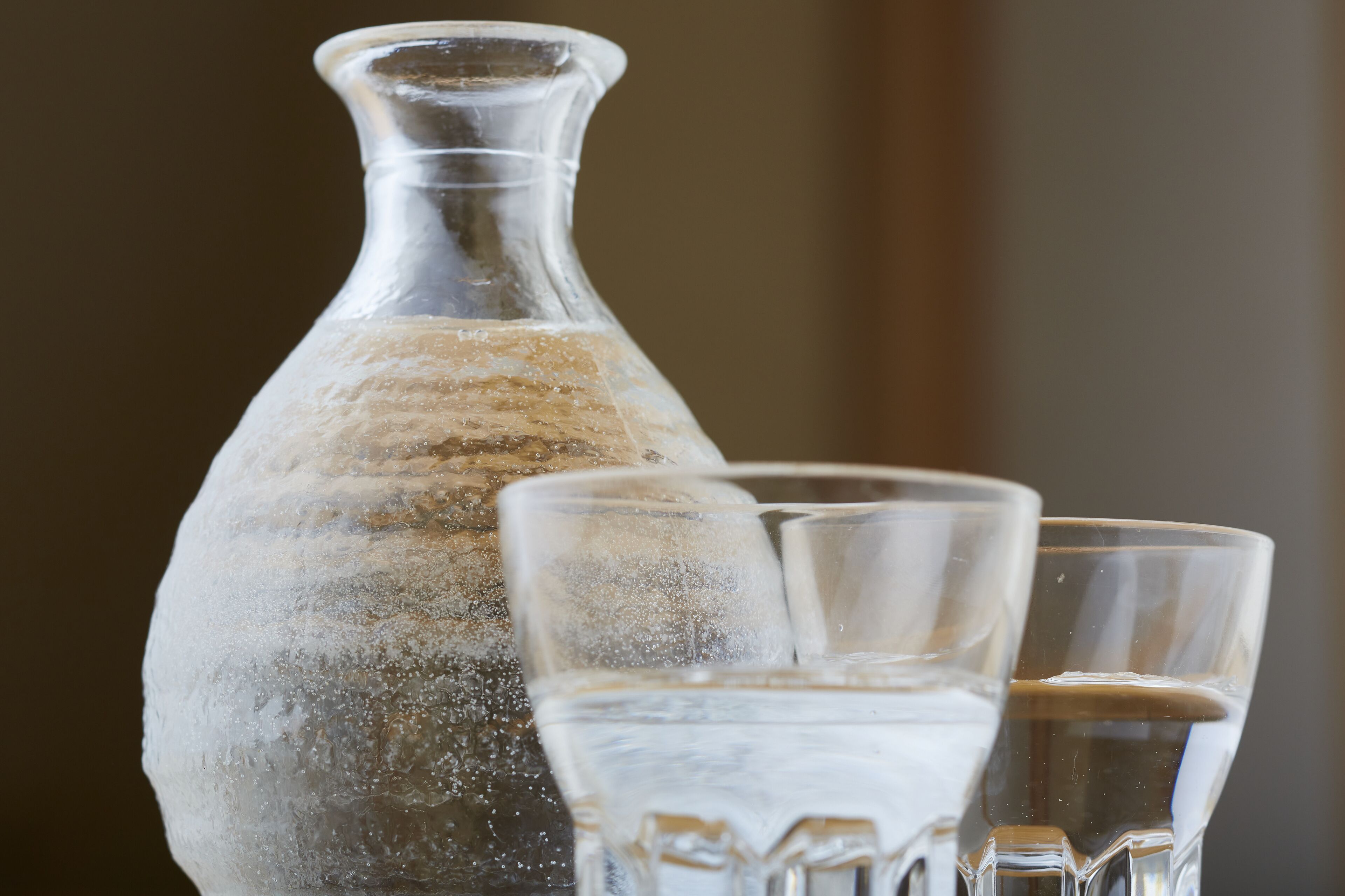 Une bouteille en verre transparent et deux verres contenant des glaçons.