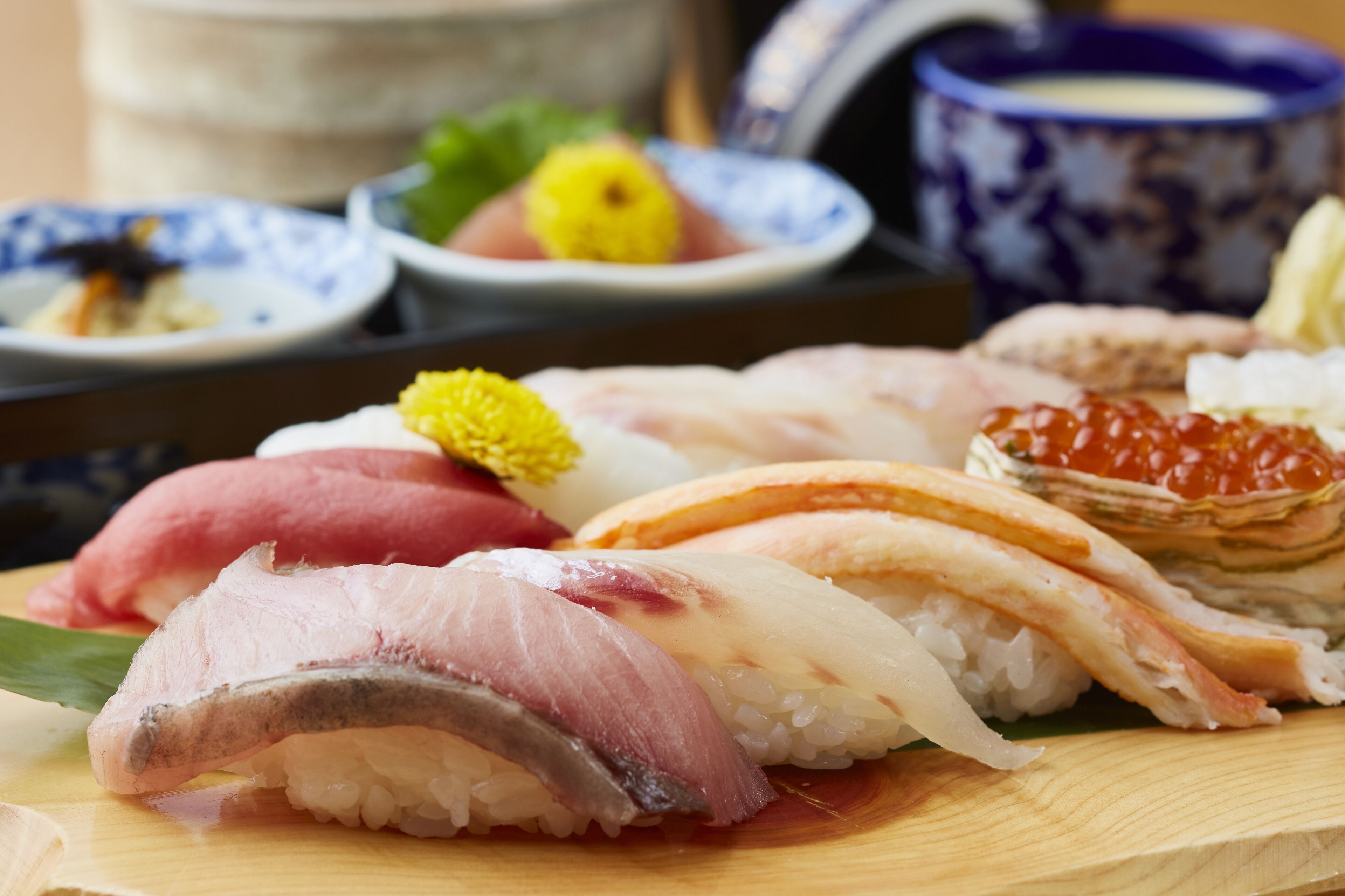 A variety of sushi on a wooden board.