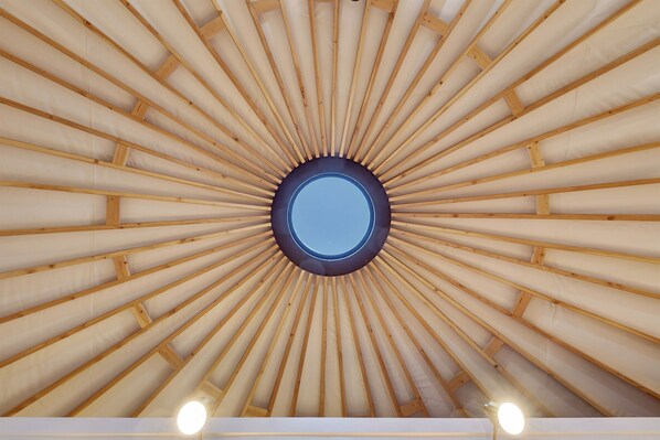 A circular skylight with wooden beams radiating outward.