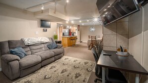 Un espacio habitable compacto con sofá, una mesa de comedor y una zona de cocina.