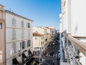 Un carrer estret flanquejat per edificis d'alguns pisos, amb balcons i una combinació d'estils arquitectònics.