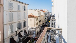 A narrow street with buildings on either side, balconies, and a clear blue sky. - 2-Br. steps from the Palais des Festivals (Cannes)