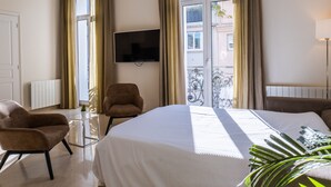 A hotel room with a bed, a chair, a TV, and a window with curtains. - 2-Br. steps from the Palais des Festivals (Cannes)