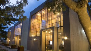 A modern building with large windows and a brick entrance. - The Cubes Apartments (Lusaka)