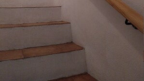Een trap met houten leuningen en witte muren.