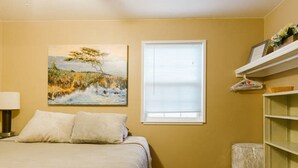 A bedroom with a bed, a painting, a window, and a shelf. - San Pablo 30 nights or more (Seaside)