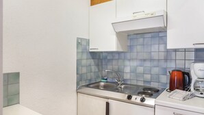 Een keuken met een spoelbak, fornuis en koffiezetapparaat.