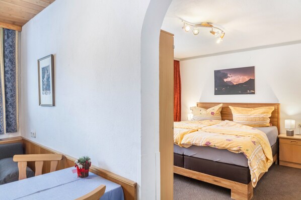 Une chambre à coucher avec un lit, une table de chevet, une lampe et un tableau encadré au mur.
