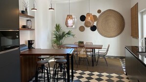 Une cuisine moderne dotée d’un îlot central, de tabourets de bar, de luminaires suspendus et d’un ventilateur de plafond.