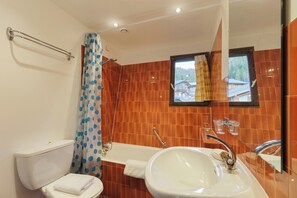 Une salle de bain avec des toilettes, un lavabo et une douche.