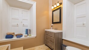 A bathroom with a window, a sink, a mirror, and a toilet. - 3rd floor unit with Picturesque Ocean View and outdoor seating! (Frederiksted)