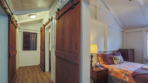 Een slaapkamer met een groot bed, een nachtkastje, een lamp en een kledingkast.