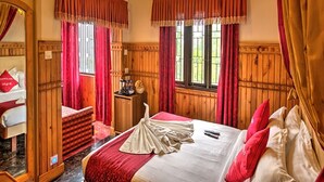 A hotel room with a bed, a wooden headboard, a nightstand, and a window with curtains. - Pine Borough Inn (Kodaikanal)