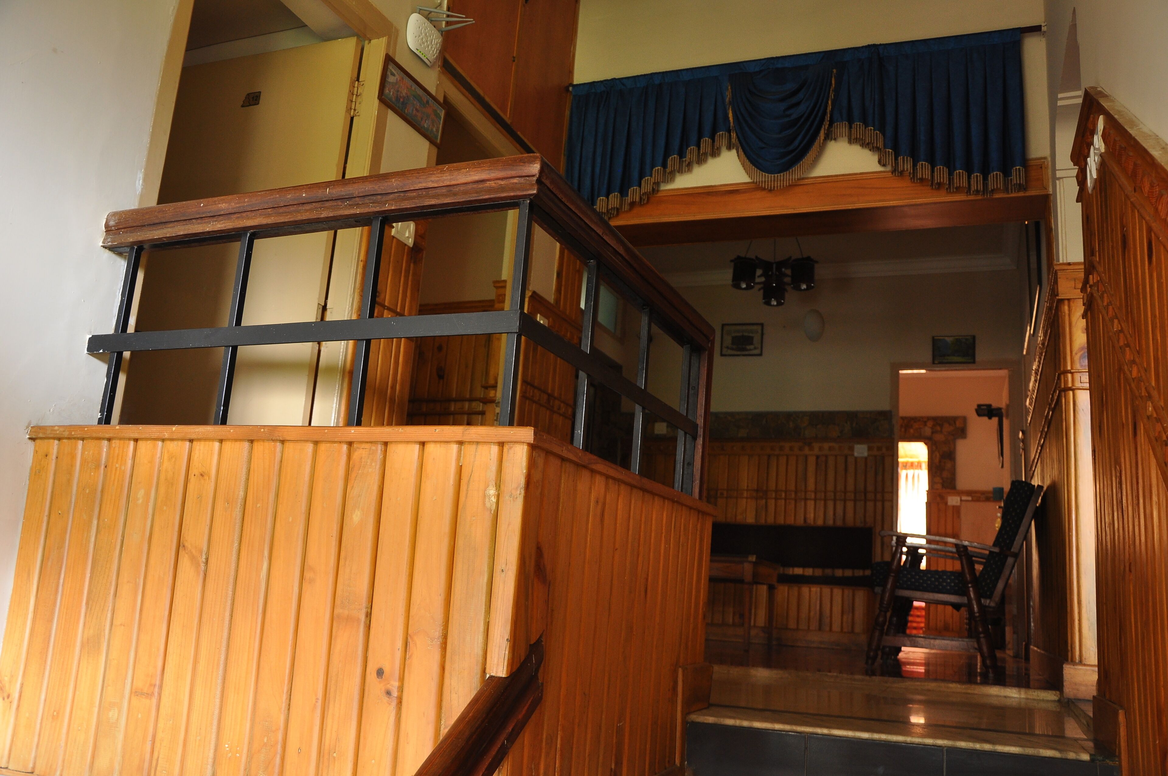 A wooden staircase with a railing, leading to a lower level.