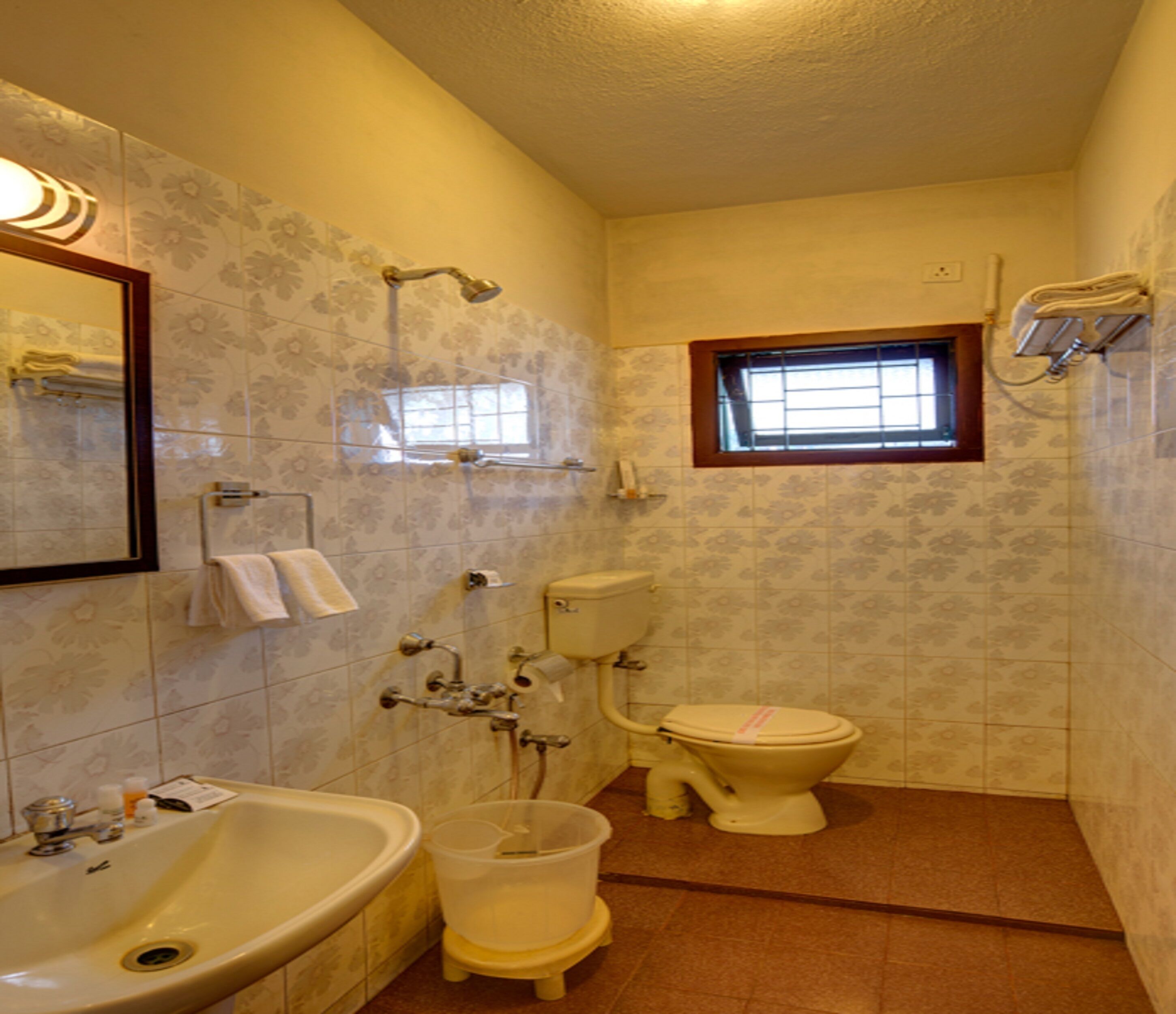 A bathroom with a bathtub, toilet, and sink. There is a window above the toilet.
