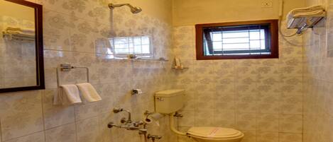 A bathroom with a bathtub, toilet, and sink. There is a window above the toilet.