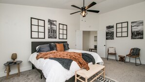 A bedroom with a bed, a ceiling fan, a small table, and two chairs. - Upgraded 4-bdrm Beautiful Home W/pool! (Glendale)