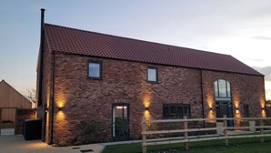 A brick building with a red-tiled roof, a wooden fence, and a paved driveway. - Chestnut House, Ashlin Farm Barns (Lincoln)
