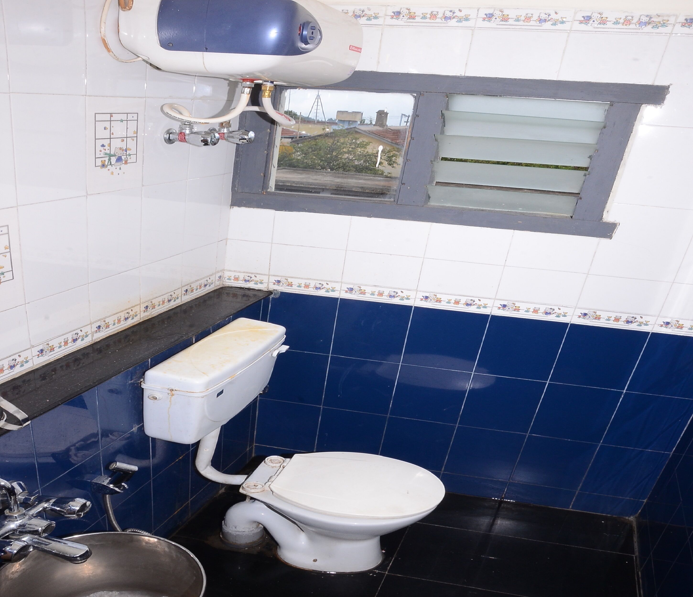 Une petite salle de bain avec des toilettes, un lavabo et une fenêtre.