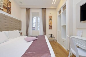 A hotel room with a large bed, a desk, and a wardrobe. - alla locanda Malandra (Rome)