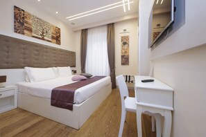 A modern hotel room with a large bed, a desk, and a chair. - alla locanda Malandra (Rome)