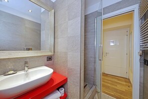 A modern bathroom with a large mirror, a white sink, and a red vanity. - alla locanda Malandra (Rome)