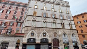 A multi-story building with arched windows and a stone facade. - alla locanda Malandra (Rome)