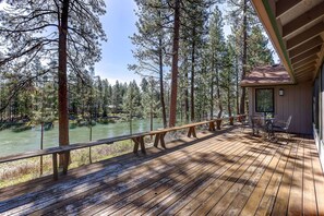 A wooden deck with a view of a river and forest. - Incredible Riverside Home, River Views and Access, Huge Deck, Bikes, Close to Golf, Courts, and Pool (Sunriver)
