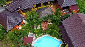 An aerial view of a resort with multiple buildings, a swimming pool, and lush greenery. - Alona's Coral Garden Resort  (Panglao)