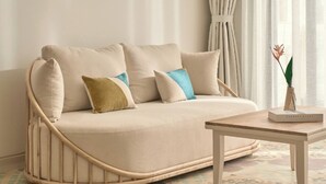 A modern living room with a curved sofa, a wooden coffee table, and patterned floor tiles. - Moodhoian Riverside Resort & Spa (Da Nang)