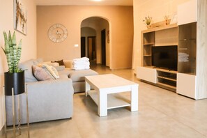 Relax in this stylish living room with a sofa set, coffee table, and flat-screen TV.