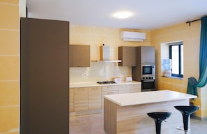 Enjoy cooking in this well-equipped kitchen with a central island, oven, microwave, and gas stove.