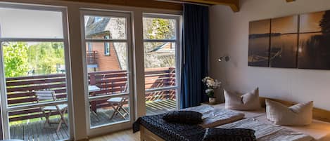 Un dormitorio con cama, una banca y vistas a una terraza exterior.