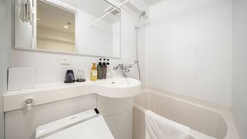 A modern bathroom with a white sink, a mirror, a handheld showerhead, and a towel rack.