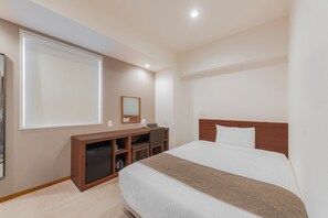 A hotel room with a bed, a desk, a chair, a small cabinet, a mirror, and a window. - Hotel Reference Hakata Reisen (Fukuoka)