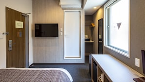 A hotel room with a bed, a TV mounted on the wall, a wardrobe, and a window with a view. - Hotel Reference Hakata Reisen (Fukuoka)