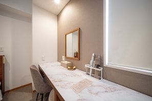 A hotel room with a marble vanity, a mirror, a towel, and a wall-mounted hairdryer. - Hotel Reference Hakata Reisen (Fukuoka)