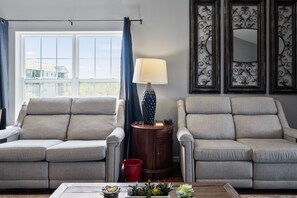 Enjoy conversation and views from this cozy living room with a large window and comfortable seating area.