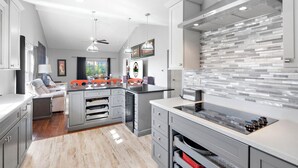 A modern kitchen with grey cabinetry, a central island, and a backsplash with rectangular tiles. - 3BR/3BA Golf Course Condo • Upgraded Kitchen • Discount Tickets & Golf! (Branson)