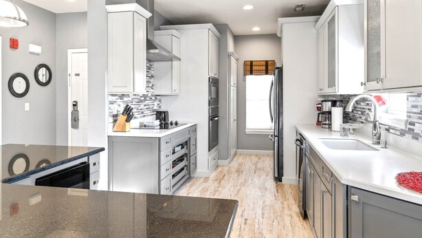 A modern kitchen with white cabinetry, a granite countertop, and stainless steel appliances. - 3BR/3BA Golf Course Condo • Upgraded Kitchen • Discount Tickets & Golf! (Branson)